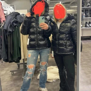 Svart glansig pufferjacka med huva - Säljer en svart, glansig jacka från Everest köpt förra vintern och sparsamt använd. Den är i bra skick och har inga defekter. Jättesnygg passform. Storlek 36/S/M. Nypris 1300