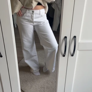 Vita wide jeans med hög midja - Säljer ett par vita jeans med hög midja och wide fit. Byxorna har klassisk femficksdesign och raka, vida ben. Perfekta för dig som gillar en avslappnad och trendig look.