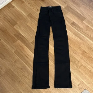 Svarta skinny jeans - Svarta jeans med skinny passform och klassisk femficksdesign. Byxorna har hög midja och raka ben som blir vidare nertill. Perfekta för dig som gillar en tidlös och clean look. Materialet är mjukt och stretchigt för extra komfort.