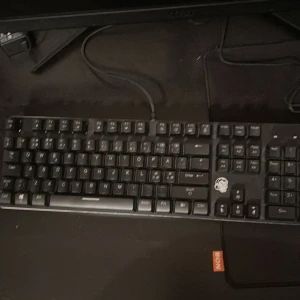 Biltema Gaming RGB Mekaniskt Tangentbord - Mekaniskt tangentbord med RGB-belysning från Biltema gaming keyboard . Fullstort med numerisk del, slitstarka tangenter och gamingdesign. USB-anslutning. Tangenter och belysning fungerar bra, mindre slitage syns på vissa tangenter. Perfekt för gaming och produktivitet. 