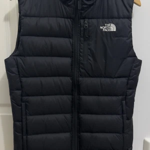 Svart väst från The North Face - En riktigt snygg svart väst från The North Face. Modell 550 som är ganska svår att få tag på nu. Har använts för ungefär 3-4 år sedan, efter det har den bara varit förvarat i garderoben och inte använts. Vill tillägga några extremt små vitt ull kan ibland kommas ut, har hänt väldigt få gånger. Nypris cirka 1100kr  Några funderingar eller fler bilder, hojta bara till!