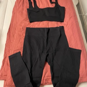 Svart ribbat sett - Säljer ett par svarta ribbade leggings med hög midja och en sport bh med inbyggda kupor. Storlek L men funkar som M