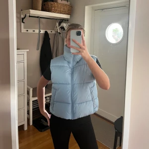 Ljusblå dunväst - Ljusblå dunväst från BikBok i storlek Xs. Aldrig använd. 