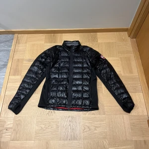 Svart dunjacka från Canada Goose - Säljer en svart dunjacka från Canada Goose. Jackan är köpt på Canada Goose butiken i New York. I stort sätt oanvänd och är nyskick. Inga defekter. Storleken är L men den passar även M