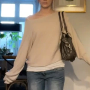 Beige oversized offshoulder tröja - Säljer en supermjuk och oversized beige tröja med offshoulder-look. Tröjan har långa ärmar och en avslappnad passform som ger en chill vibe. Perfekt att styla med jeans eller kjol för en trendig och bekväm outfit. SKRIV FÖR FLER BILDER☺️