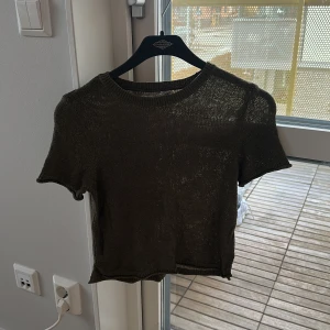 Olivgrön stickad topp från ONLY - Säljer en olivgrön stickad topp från ONLY i storlek XXS. Toppen har korta ärmar, rund halsringning och är lätt transparent med en loose passform. Perfekt för dig som gillar chill och enkel stil med lite edge.