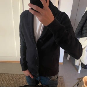 Stickad cardigan  - Säljer nu en fet stickad cardigan i storlek M. Jag är 187 skriv för fler bilder eller funderingar. Tröjan är mörkblå/svart.