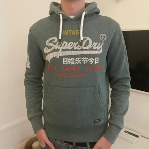 Grön Superdry hoodie med tryck - Snygg superdry hoodie i storlek M. Modellen är 187 men hoodien passar 175-190! Skriv vid minsta fundering🤗