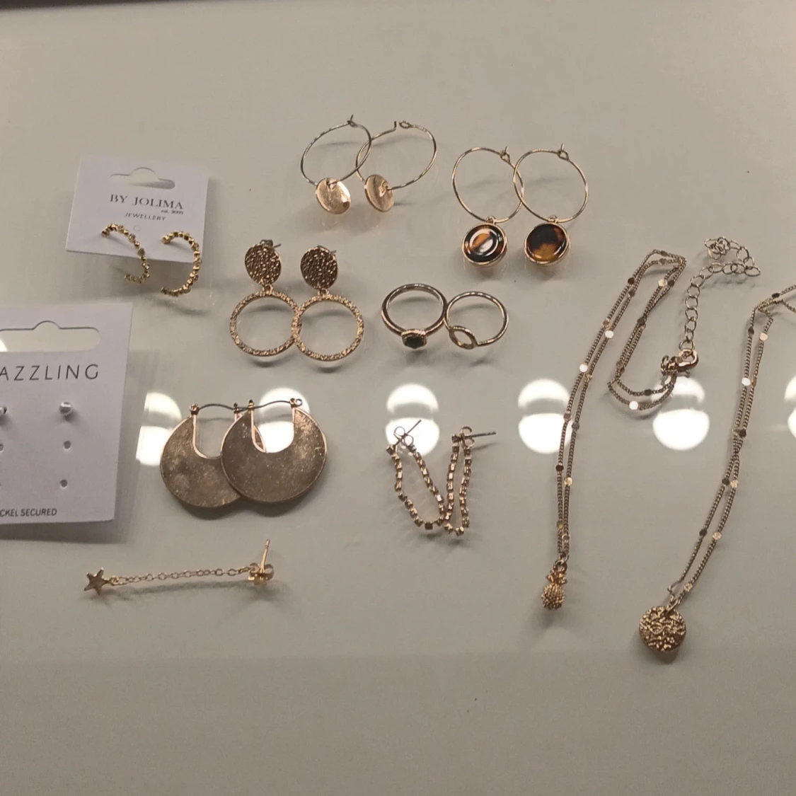 Mix av guldiga smycken och örhängen