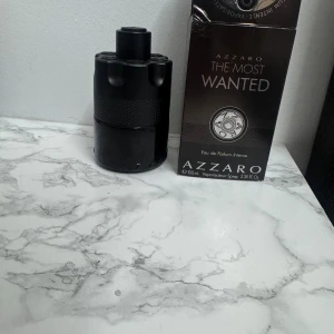 Azzaro The Most Wanted 100ml - Azzaro The Most Wanted Eau de Parfum Intense i en cool, svart flaska. Volym: 100 ml. Perfekt för dig som vill sticka ut och göra intryck. Snygg design och populär bland unga.