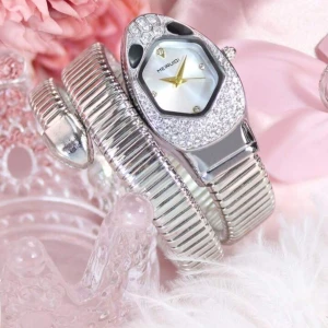 Elegant Silverklocka med Justerbar Rem - Stilren damklocka i silver med glittrande detaljer och modern design. Orm-inspirerad form och flexibel, justerbar rem som passar de flesta handleder. Perfekt för både vardag och fest. Ny och oanvänd. Pris: 250 SEK. Justerbar storlek. Färg: silver.