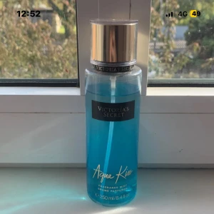 Victoria's Secret Aqua Kiss mist - Fräsch och trendig body mist från Victoria's Secret. Aqua Kiss kommer i en snygg blå flaska med sprayfunktion. Volym: 250 ml. Perfekt för dig som vill ha en lätt och uppfriskande doft att använda varje dag.