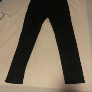 Svarta jeans Tiger of Sweden Sandie - Svarta jeans från Tiger of Sweden i modellen Sandie. Byxorna har klassisk femficksdesign och smal passform. Snygga och stilrena, perfekta till många olika outfits. Tillverkade i ett stretchigt material för extra komfort. Priset går att prata om