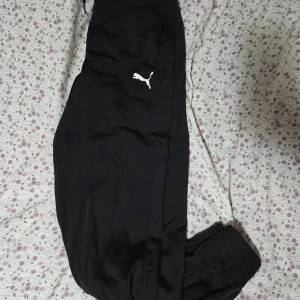 Puma svarta träningsbyxor, storlek S - Ett par svarta träningsbyxor med resår i midjan och vid anklarna.