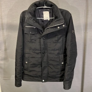 Field jacka j lindeberg svart S - En supersnygg och trendig field jacka från j lindeberg! Jackan är svart! Size S. Modellen är 179cm! Skick 8,5+/10. Begagnad men bra skick utan defekter eller skador! Nypris ca 3000kr. Hör av dig vid frågor eller funderingar 🤩