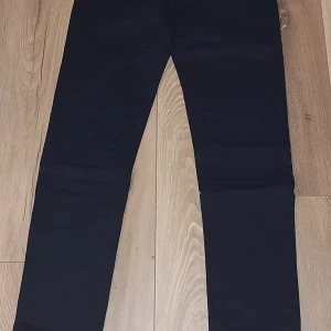 Svarta jeans från Jacob Cohën - Snygga svarta jeans från Jacob Cohën med klassisk femficksdesign och diskret logopatch i svart på bakfickan. Jeansen har en slim passform och är tillverkade i mjukt bomullsmaterial med stretch för extra komfort. Perfekta för dig som gillar stilrena och moderna byxor.