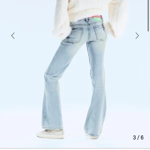 Ljusblå bootcut jeans med slitningar - Säljer ett par ljusblå bootcut jeans med klassisk femficksdesign och snygga slitningar framtill. Jeansen har låg midja och jag har sprättat bort lappen där bak. 