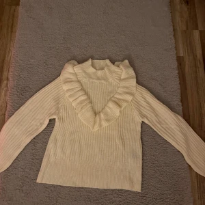 Ribbad beige stickad tröja med volang - Säljer en jätte söt stickad tröja med volanger fram till. Använd en gång🤍