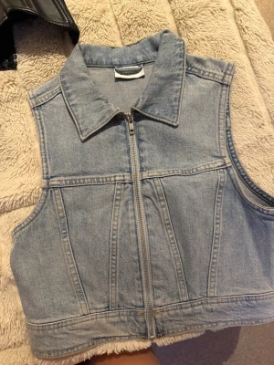 Ljusblå jeansväst från Weekday - Säljer en ljusblå jeansväst från Weekday med krage och dragkedja framtill. 