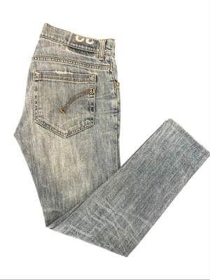 Ljusblå jeans från Dondup  - Snygga ljusblå jeans från Dondup med klassisk femficksdesign och unika detaljer som dragkedja på bakfickan. Jeansen har en smal passform och är tillverkade i denim med lätt tvättad look. Perfekta för en avslappnad och trendig stil. Personen på bilden är 167