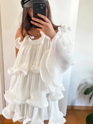 Student klänning  - Superfin vit volang klänning, från Lojsans kollektion med NAKD. Passar perfekt för student/avslutning eller bara fin i sommar❤️Den är använd endast en gång. Sista bilen är min egna❤️skulle säga att den passar xs-m❤️