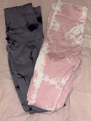 Två par tie-dye leggings - Säljer två par snygga leggings med tie-dye mönster, ett par i grått och svart och ett par i rosa och vitt. Perfekta för träning eller chill. Stretchigt material som sitter skönt och följer kroppen. Säljer båda tillsammans för 40 kr 