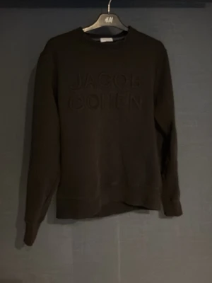 Svart sweatshirt från Jacob Cohën - Cool svart sweatshirt från Jacob Cohën med broderad logga framtill. Tröjan har rund halsringning och långa ärmar. Perfekt för en avslappnad och stilren look.