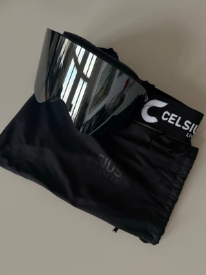 Celsius skidglasögon - Svarta Celsius skidglasögon med spegelglas och elastiskt band, samt tillhörande förvaringspåse.