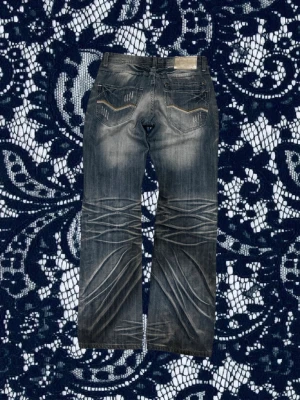 Faded slitna jeans från F.E.N - Säljer ett par grå jeans från F.E.N med slitna detaljer och markerade sömmar. Jeansen har raka ben, fem fickor och coola slitningar både fram och bak. Jeansen har även otroligt snygg tvätt med sjuka ”honeycombs” som ger dem en fet och unik look!