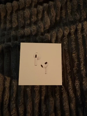 Apple AirPods 3  - Säljer ett par vita Apple AirPods med MagSafe-laddningsetui. Trådlösa in-ear-hörlurar med stilren och minimalistisk design, perfekt för musik, samtal och vardagsbruk. Kompatibla med Apple-enheter och levereras i originalförpackning.