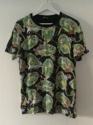 Rick and Morty t-shirt - En svart Rick and Morty t-shirt med färgglatt all-over tryck av karaktärer och portaler från serien. T-shirten har rund hals och korta ärmar.