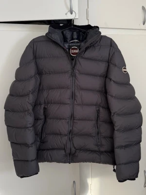 Colmar jacka  - En mycket snygg Colmar dunjacka i mörk färg, stilren och perfekt för vardag och kyligare dagar. Tidlös design med huva och en sportig, exklusiv känsla.  Jackan är i mycket bra skick och väl omhändertagen.  ✅ Märke: Colmar ✅ Storlek: 48 (motsvarar S) ✅ Färg: Mörkgrå/svart ✅ Skick: Mycket bra ✅ Stil: Snygg & tidlös  En riktigt fin Colmar-jacka – redo att användas direkt.