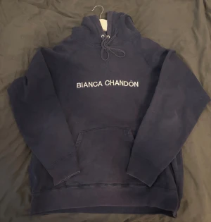 Mörkblå hoodie från Bianca Chandon  - Schysst mörkblå hoodie från Bianca Chandon i storlek M men kan funka för S. Tröjan har huva med snörning, stor magficka och vit broderad logga på bröstet. 