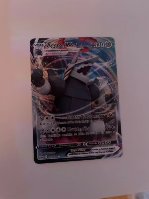 Aggron VMAX - Coolt Pokémonkort med Aggron VMAX! Perfekt för dig som samlar eller spelar Pokémon TCG. Kortet har snyggt holografiskt motiv och är på spanska. Ett måste för alla unga Pokémonfans som vill boosta sin samling med en kraftfull VMAX!