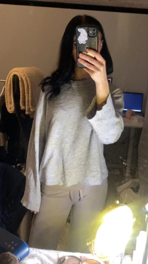 Ljusgrå stickad tröja med vida ärmar - Mysig ljusgrå stickad tröja med avslappnad passform och vida, långa ärmar. Perfekt för lager-på-lager och chill dagar. Enkel och stilren design som är lätt att matcha med olika outfits.