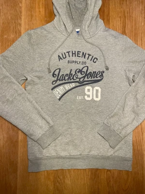 Jack and Jones hoodie - En jack & jones hoodie i mycket bra skick. Storleken är S och den passar någon mellan 170-178. Hoodien har ett klassiskt jack and jones tryck på bröstet. Pris ej hugget i sten🪨🪨!