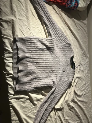 Grå stickad tröja Polo Ralph Lauren - Säljer en grå stickad tröja från Polo Ralph Lauren i storlek M. Tröjan har ett klassiskt kabelstickat mönster, långärmade och rund hals. På bröstet finns den ikoniska broderade loggan i svart. Perfekt för dig som gillar stilrena och tidlösa plagg. Själv är jag 182 och den sitter lite tajt på mig och då kan jag rekommendera starkt till en lite kortare! Den har en sydd area, men märks endast vid påpekande eller vid nära avstånd! 