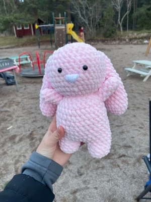 Virkad rosa kanin - Virkad rosa kanin. Går att stå upp om den lutas mot en vägg. Har pålimmade plastögon så rekommenderas inte för barn under 3 år. Det går att jämföra storleken med min hand men annars kan du såklart skriva till mig och fråga om mer exakta mått🫶🏻💕och skriv även vid andra frågor 