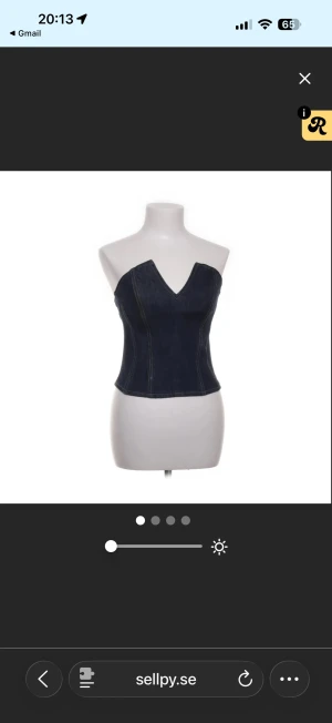 Mörkblå denim korsett med v-ringning - Snygg mörkblå korsett i denim med markerade sömmar och v-ringad hals. Toppen är axelbandslös och har en figurnära passform som framhäver midjan. Perfekt för dig som vill ha en cool och trendig look med lite edge.