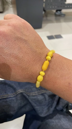 Bärnsten - Snyggt armband med gula pärlor i olika former och storlekar. Pärlorna är runda och avlånga, vilket ger ett lekfullt och trendigt uttryck. Perfekt för dig som gillar färg och vill sticka ut lite extra med accessoarer.