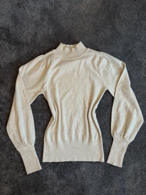 Finsticksd tröja med puffiga ärmar  - Finstickad tröja i beige ifrån Veromoda, lite tightare i slutet av ärmarna o nere av tröjan. 