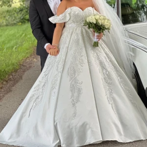 Brudklänning  - Säljer denna fina brudklänning med underkjol. Klänningen är kemtvättad och är i stl 38 men finns korsett så funkar för en 36 eller 40 också.   Säljer även en tiara, en lång och en kort slöja till. Pris: 1800kr 