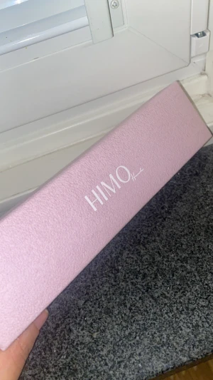 Guldarmband med vit fyrklöver från HIMO - Supersött armband från HIMO med tunn guldfärgad kedja och en vit fyrklöver som detalj i mitten. Kommer i en lyxig rosa ask med logga. Perfekt för dig som gillar stilrena och trendiga smycken med en liten twist.