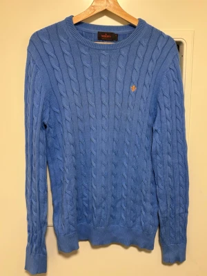 Blå kabelstickad tröja från Morris - Fin blå kabelstickad tröja från morris. Knappt använd extremt bra skick. Storlek Medium