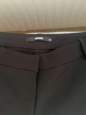 Svarta kostymbyxor från BikBok - Säljer ett par svarta kostymbyxor från BikBok i storlek 38. De är för långa för mig så de kommer inte till användning! De är som helt nya och har inga defekter. Kontakta för frågor💕