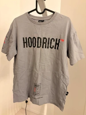 Grå HOODRICH t-shirt  - En grå t-shirt från HOODRICH med tryck både fram och bak. 