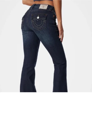 Mörkblå bootcut jeans true religion - Snygga mörkblå jeans med bootcut passform och tydliga kontrastsömmar ifrån True religion. Modellen Becca, mid waist. Jeansen är köpte för ungefär 1 år sen, knappt använda 
