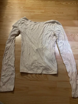 Vit långärmad topp Gina Tricot XXS - Säljer en vit långärmad topp från Gina Tricot i storlek XXS. Toppen har en enkel och stilren design med rund halsringning och är tillverkad i mjuk bomull. Perfekt att matcha med jeans eller kjol för en clean look. Använd 1 gång 