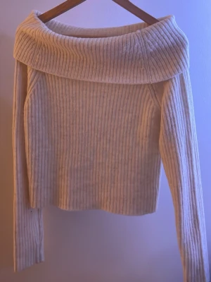 Offshoulder ribbad stickad tröja - Säljer en supermysig offshoulder tröja i ribbad stickad kvalitet. Färgen är ljus beige och har en fin och gullig passform, perfekt för en mysig och sofistikerad look. Tröjan är ny utan prislapp. Tröjan är i storlek 170 men passar fint på storlek xs/s. Pris kan diskuteras💗