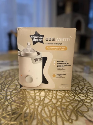 Ingen väst på bilderna - Bilderna visar en flaskvärmare från Tommee Tippee, inte en väst. Ingen väst kan beskrivas utifrån dessa bilder.